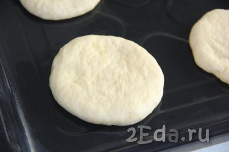 Раскатать кусочки теста в круглые лепешки толщиной, примерно, 1,5-2 см. Выложить лепёшки на некотором расстоянии друг от друга на противень, смазанный маслом, и оставить их на 20-30 минут для подъема. 