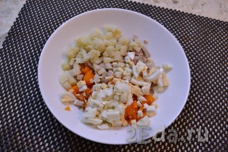К нарезанным моркови и курице добавить нарезанные кубиками картофель и яйца.