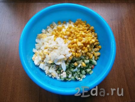 В салат из крабовых палочек, огурца и яиц добавить консервированную кукурузу, мелко и тонко нарезанный очищенный репчатый лук.