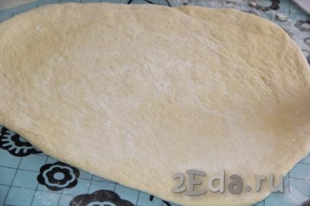 На припыленном мукой столе обмять готовое тесто и раскатать в пласт толщиной, примерно, 0,5 см. 
