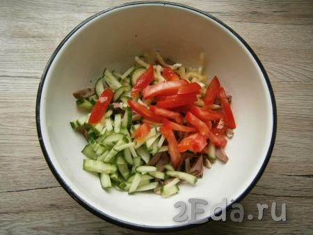 Нарезать произвольно свежий огурец и помидор, выложить в салат из свиного сердца и перца.