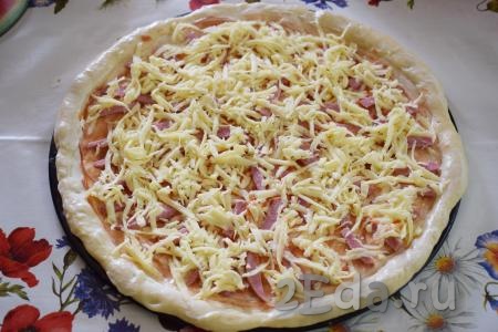 Сверху посыпать пиццу натертым на крупной терке сыром.