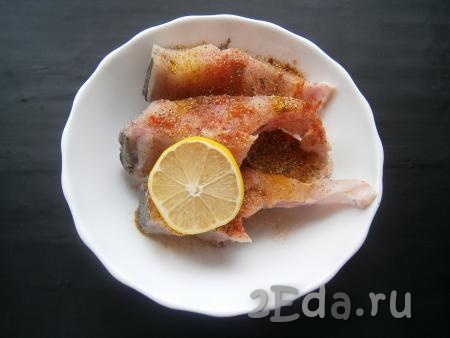 Кусочки рыбки посолить, поперчить чесночным перцем, добавить лимонный сок, порошок карри, паприку, перемешать, чтобы специи равномерно распределились.