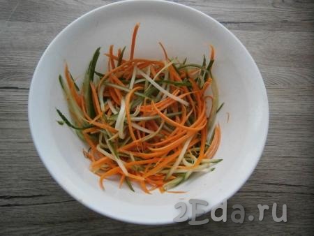 Очищенную морковь, натерев на терке для корейской моркови, выложить к огурцам, посолить и перемешать.