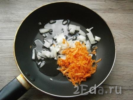 Лук нарезать кусочками, морковь натереть на крупной терке, выложить овощи в сковороду, влить растительное масло.