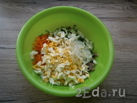 Лук отжать от маринада и добавить в салат вместе с рубленными яйцами.
