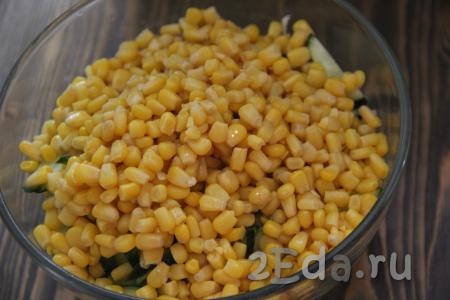 С кукурузы слить жидкость и добавить кукурузу в салат из капусты и огурцов.
