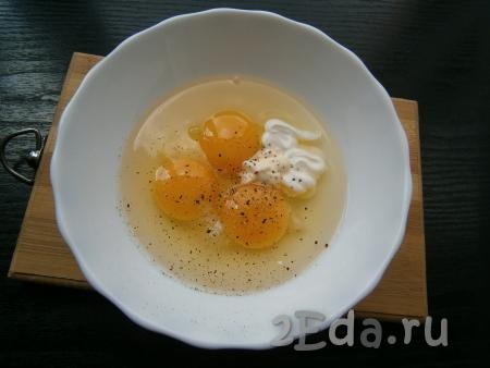 К сырым яйцам добавить сметану, майонез, немного соли и черного молотого перца.