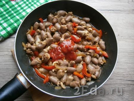 Влить соевый соус, перемешать и обжарить куриные сердечки с овощами 3-4 минуты на среднем огне, иногда перемешивая. Далее добавить в сковороду томатный соус.
