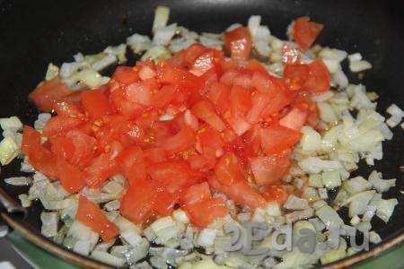 Мелко нарезать очищенный от шкурки помидор и добавить в сковороду к луку. Обжарить овощи, помешивая, в течение 3-5 минут на среднем огне.