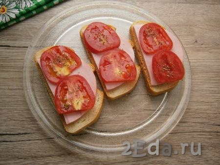 Ломтики вареной колбасы выложить на хлеб, а сверху - кружочки помидора, которые посыпать немного итальянскими травами.