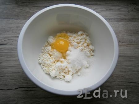 Для приготовления теста к творогу добавить сырое яйцо, всыпать 2 столовые ложки сахара, соль и соду.