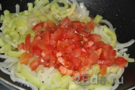 Помидор, очищенный от шкурки, мелко нарезать, выложить в сковороду с овощами, перемешать и потушить минут 5-7 на небольшом огне.
