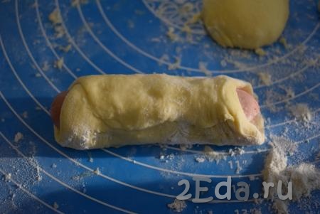 Сосиску заворачиваем в тесто, скрепляя края (как на фото). Аналогично формируем все сосиски в тесте.