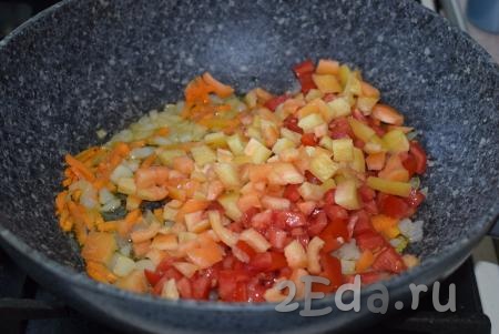 Сразу же накроем сковороду крышкой и будем томить овощи на небольшом огне до прозрачности лука (примерно, 10-12 минут), периодически помешивая. Далее добавим в сковороду болгарский перец и помидоры.