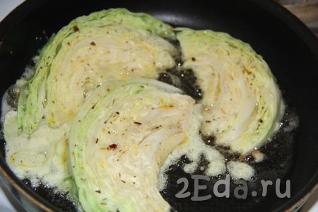 В сковороду влить растительное масло и разогреть. Выложить дольки капусты в сковороду так, чтобы они заполнили все дно.