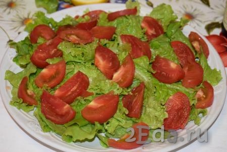 На листья салата выкладываем нарезанные на дольки помидоры.
