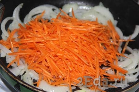 Очищенную морковь, натертую на крупной тёрке (или на тёрке для моркови по-корейски), выложить на сковороду к обжаренному луку.