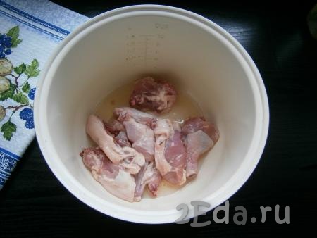 Курицу порубить на части, выложить в чашу мультиварки, добавить растительное масло.