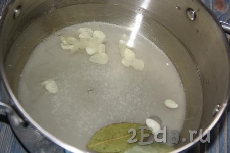 Для приготовления маринада влить воду в кастрюлю, добавить сахар, соль, лавровые листья, очищенный чеснок, нарезанный тонкими пластинками.
