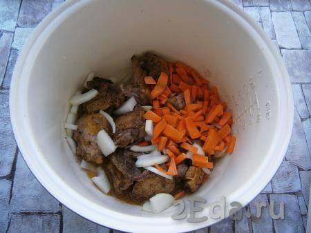 Добавить к обжаренному мясу очищенные и произвольно нарезанные лук и морковь.