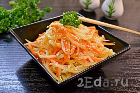 Вкусный, остренький салат из дайкона с морковью выложить в салатник горкой, посыпать кунжутом, украсить петрушкой и подать к столу.