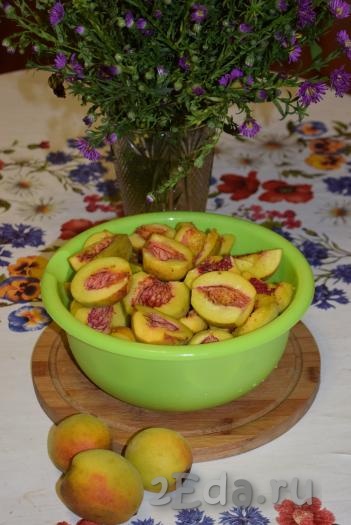 Для приготовления персикового варенья лучше выбирать спелые, но не мягкие плоды. Персики вымыть, обрезать битые места. Разрезать персики на половинки и удалить косточки. Должен получиться 1 килограмм персиков, очищенных  от косточек.