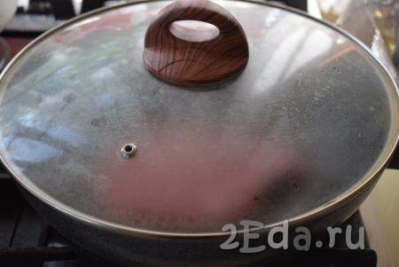 Накрыть сковороду крышкой и жарить свиные отбивные на косточке на среднем огне сначала с одной стороны, примерно, 5 минут. 