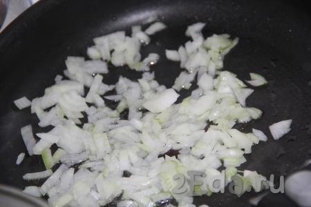 В сковороду добавить растительное масло, очищенный и мелко нарезанный лук. Обжарить лук, помешивая, до мягкости.