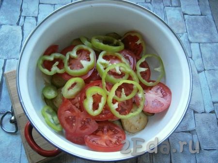 Добавить нарезанный колечками сладкий болгарский перец, предварительно очищенный от семян, и нарезанные кружочками помидоры.
