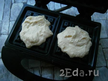 Форму для вафель смазать сливочным маслом, выкладывать в ячейки по 2-3 столовые ложки теста.