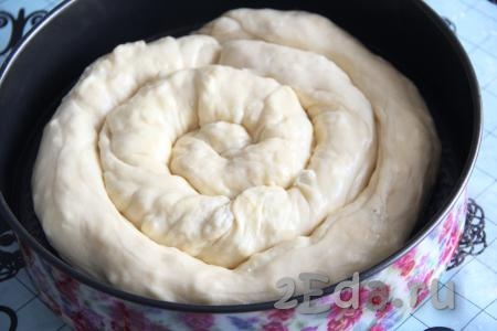 Форму для выпечки смазать растительным маслом (у меня форма диаметром 28 см). Разложить пирог в форме в виде улитки.