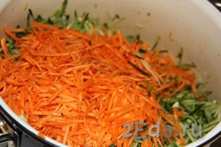 Очищенную морковь, натерев на тёрке для моркови по-корейски, выложить в кастрюлю к огурцам.