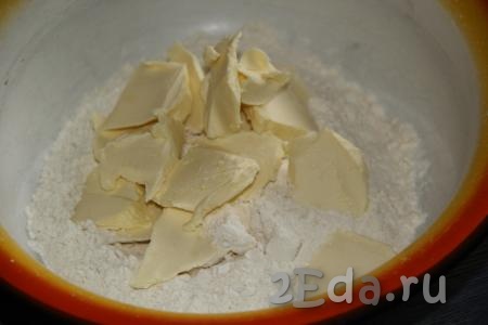 В миску всыпать муку, соль и сахар, добавить холодное масло, нарезанное на кусочки.