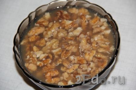 Ядра грецких орехов крупно порубить и залить горячим кипятком на 10 минут. Орешки распарятся и лучше в дальнейшем впитают сироп.