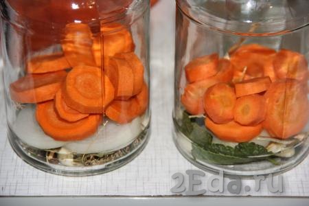 Морковь очистить и нарезать на кружочки толщиной 1 см. Выложить в каждую банку слой лука, поверх лука - слой морковки.