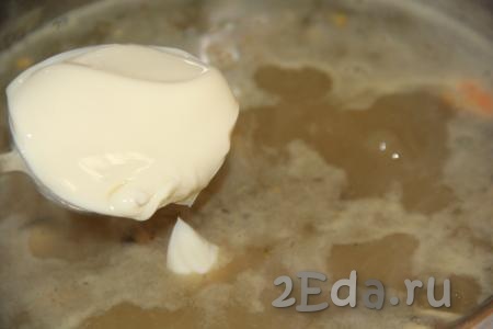 Добавить в суп плавленный сыр, перемешать. Проварить сырный суп с морепродуктами до полного растворения сыра (пару минут).
