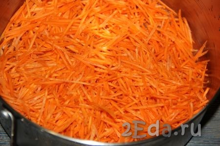 Очищенную морковь натереть на тёрке для моркови по-корейски, выложить в большую кастрюлю (я использую кастрюлю объёмом 7 литров).