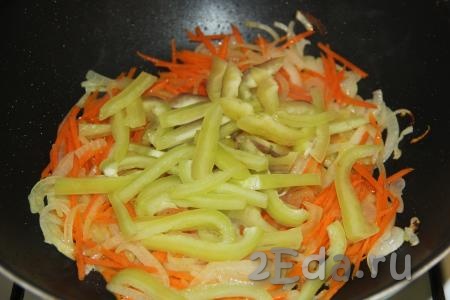 Обжарить морковку с луком на среднем огне, помешивая, пару минут. Болгарский перец, удалив из него семена, нарезать тонкими полосками и добавить к луку и моркови.