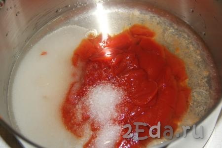 В большую кастрюлю влить воду, добавить сахар, соль и томатную пасту, хорошо перемешать и поставить на огонь.