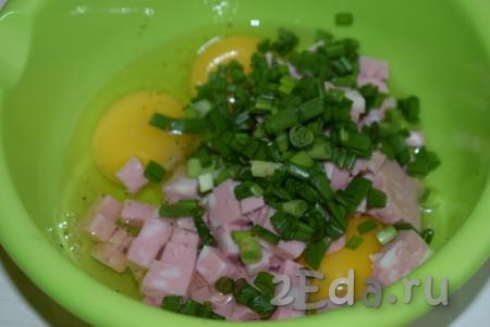 В миску к яйцам добавим измельченные колбасу и зеленый лук.