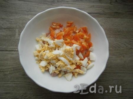 Перец болгарский нарезать небольшими квадратиками, яйца порубить. Яйца и болгарский перец добавить в салат из лука и ветчины.