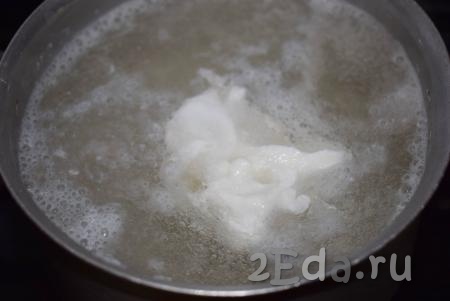 Берём сырое куриное яйцо, аккуратно разбиваем скорлупу, стараясь не повредить оболочку желтка, и выкладываем в подходящую посуду (пиалу или чашку). Далее большой ложкой или венчиком делаем воронку в кастрюле с водой, активно размешивая воду по кругу. В центр воронки, максимально близко поднеся посуду с яйцом к воде, аккуратно выливаем сырое яйцо, стараясь не повредить желток.