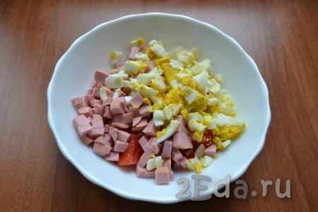Яйца очистить и нарезать кубиками. В салат из картофеля и помидоров добавить нарезанные яйца и нарезанную кубиками колбасу.