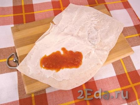 На край лаваша выложить столовую ложку томатного соуса или кетчупа.