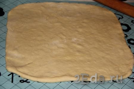 Тесто, замешанное в хлебопечке или вручную, обмять. Затем на столе, присыпанном мукой (или на силиконовом коврике), раскатать тесто в пласт размером, примерно, 40х40 см.