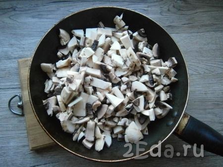 Нарезать грибы на небольшие кусочки, поместить их в разогретую с растительным маслом сковороду.