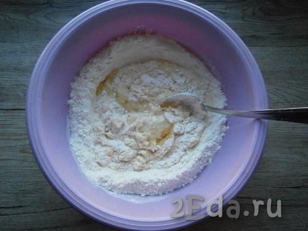 Добавить щепотку сахара и растительное масло, смешать с частью муки. Постепенно вливать кефир, замешивая тесто.