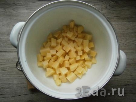 Картофель очистить и нарезать в кастрюлю небольшими кубиками.