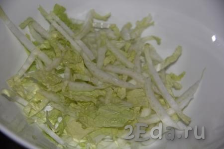 В глубокий салатник выложить нашинкованную пекинскую капусту.
